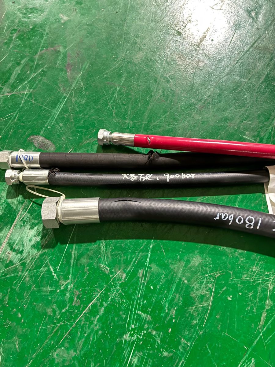 软管总成爆破测试后样品:管体标注实测爆破值(900 bar / 1800 bar,车间实拍)